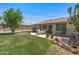 Spacious backyard featuring a well-manicured lawn, desert landscaping, and a comfortable patio seating area at 19046 N Signal Butte Cir, Sun City, AZ 85373