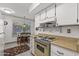 Charming kitchen with white cabinets, beige countertops, and stainless steel appliances adjacent to the breakfast area at 19046 N Signal Butte Cir, Sun City, AZ 85373