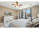 Bright bedroom with a ceiling fan, blue drapes, a large dresser with decor, creating a cozy and stylish space at 19305 E Oriole Way, Queen Creek, AZ 85142