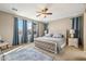 Spacious main bedroom with a ceiling fan, tufted headboard, and blue accents, creating a serene and inviting atmosphere at 19305 E Oriole Way, Queen Creek, AZ 85142