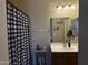 Cozy bathroom featuring a checkered shower curtain, vanity, and decorative mirror at 2132 W Gold Dust Ave, San Tan Valley, AZ 85144