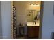 Comfortable bathroom with a checkered shower curtain, vanity, and decorative mirror at 2132 W Gold Dust Ave, San Tan Valley, AZ 85144