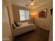 This bedroom includes neutral walls, a decorative lamp, and wood-look flooring at 2132 W Gold Dust Ave, San Tan Valley, AZ 85144
