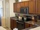 The kitchen features brown cabinetry, granite countertops, and stainless steel appliances at 2132 W Gold Dust Ave, San Tan Valley, AZ 85144