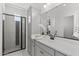 Contemporary bathroom showcasing a black-framed shower, gray cabinets, white countertop, and an elegant vanity mirror at 2149 W Rowel Rd, Phoenix, AZ 85085