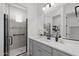 Modern bathroom featuring gray cabinets, white countertops, and a glass enclosed shower with stylish tile accents at 2149 W Rowel Rd, Phoenix, AZ 85085