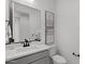 Neutral powder bath features a large mirror, artwork, and a sleek black faucet for a modern touch at 2149 W Rowel Rd, Phoenix, AZ 85085