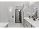 Modern bathroom featuring gray cabinets, white countertops, decorative mirror, and a shower with gray tile accents at 2149 W Rowel Rd, Phoenix, AZ 85085