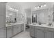 Dual vanity bathroom with gray cabinets, white countertops, modern lighting, and a view into the main bedroom at 2149 W Rowel Rd, Phoenix, AZ 85085
