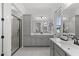Spacious bathroom with gray cabinets, dual sinks, decorative mirrors, and a glass-enclosed shower at 2149 W Rowel Rd, Phoenix, AZ 85085