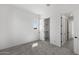 Bright, vacant bedroom with neutral gray carpeting, closet, white walls and trim and an attached room at 2149 W Rowel Rd, Phoenix, AZ 85085