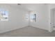 Bright bedroom with neutral carpet, fresh white walls, and abundant natural light from three windows at 2149 W Rowel Rd, Phoenix, AZ 85085