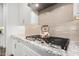 Stylish gas cooktop with a decorative teapot, set against white cabinets and granite countertops at 22867 E Via Las Brisas --, Queen Creek, AZ 85142