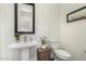 Elegant powder room featuring pedestal sink, decorative mirror, and charming decor at 22867 E Via Las Brisas --, Queen Creek, AZ 85142