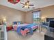 Well-lit bedroom with a ceiling fan, a window, and a bed with colorful bedding, accompanied by a desk and side table at 2307 E Pecan Rd, Phoenix, AZ 85040