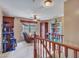 View of the loft featuring wood railing, window, ceiling fan, and space for seating and storage at 2307 E Pecan Rd, Phoenix, AZ 85040