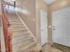 Carpeted staircase with wooden banister leads to the upper level, adjacent to the front entrance at 2307 E Pecan Rd, Phoenix, AZ 85040