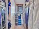Walk-in closet with hanging clothes, storage containers, and a window providing natural light at 2307 E Pecan Rd, Phoenix, AZ 85040