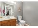 Cozy powder room features single sink vanity, framed art, toilet, and neutral color palette at 2315 W Union Hills Dr # 124, Phoenix, AZ 85027