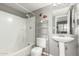 Compact bathroom with shower-tub combo, pedestal sink, and functional storage shelf for toiletries at 2315 W Union Hills Dr # 124, Phoenix, AZ 85027