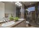 The updated bathroom features dual sinks, tiled shower with a window block, and sleek fixtures at 33601 N 64Th St, Scottsdale, AZ 85266
