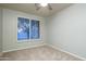 Bright bedroom featuring modern ceiling fan, carpeted floors, and plantation shutters allowing lots of natural light at 33601 N 64Th St, Scottsdale, AZ 85266