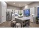 Well-lit kitchen with ample cabinet space, stainless steel refrigerator, and a center island with bar stools at 33601 N 64Th St, Scottsdale, AZ 85266