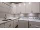 Bright laundry room featuring lots of cabinet space, modern washer and dryer units, and a sink at 33601 N 64Th St, Scottsdale, AZ 85266