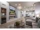 Open-concept living space with a modern fireplace, TV, chandelier, and view into the kitchen at 33601 N 64Th St, Scottsdale, AZ 85266