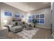 Cozy living room with a gray sectional sofa, a chandelier, and large windows with natural light at 33601 N 64Th St, Scottsdale, AZ 85266