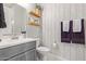 Stylish half bathroom with gray vanity, patterned accent wall, and floating wood shelves above the toilet at 4090 S Virginia Way, Chandler, AZ 85249