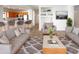 Inviting living room featuring comfortable seating, a stylish rug, and seamless flow into the kitchen at 41220 N Belfair Way, Anthem, AZ 85086