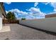Expansive backyard featuring gravel, a white block wall, and well-kept greenery at 5109 W Sanna St, Glendale, AZ 85302