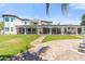 Beautiful backyard featuring a well-manicured lawn, inviting pool, spacious covered patio, and elegant architecture at 521 E Horseshoe Ave, Gilbert, AZ 85296
