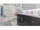 Stylish bathroom featuring a black vanity with a marble countertop and a glass-enclosed shower at 521 E Horseshoe Ave, Gilbert, AZ 85296