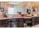 Elegant bathroom showcasing dual vanities with vessel sinks, dark cabinetry, and travertine floors for a sophisticated touch at 521 E Horseshoe Ave, Gilbert, AZ 85296