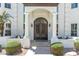 Elegant front entrance featuring an arched doorway, decorative iron doors, and manicured bushes at 521 E Horseshoe Ave, Gilbert, AZ 85296