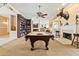 Game room offers a pool table, fireplace, bookshelf, and open access to other areas of the home at 521 E Horseshoe Ave, Gilbert, AZ 85296