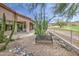 Inviting backyard with desert landscaping, covered patio, bench, and view of the golf course beyond at 5289 S Red Yucca Ln, Gold Canyon, AZ 85118
