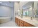 Bright bathroom featuring a dual sink vanity, jacuzzi tub, and separate glass-enclosed shower at 5289 S Red Yucca Ln, Gold Canyon, AZ 85118