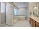 Spacious bathroom with a glass shower, jacuzzi tub, and a sink with wood cabinets at 5289 S Red Yucca Ln, Gold Canyon, AZ 85118