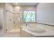 Elegant bathroom with a glass-enclosed shower, jacuzzi tub, and unique stained-glass window at 5289 S Red Yucca Ln, Gold Canyon, AZ 85118