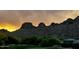 Scenic view of a golf course and desert landscape with mountains in the distance during a colorful sunset at 5370 S Desert Dawn Dr # 30, Gold Canyon, AZ 85118