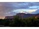 Scenic view of a home nestled amidst lush greenery with a backdrop of majestic mountains and dramatic sky at 5370 S Desert Dawn Dr # 30, Gold Canyon, AZ 85118