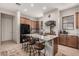 Well-lit kitchen featuring granite counters, wooden cabinets, a kitchen island with seating, and modern appliances at 5370 S Desert Dawn Dr # 30, Gold Canyon, AZ 85118