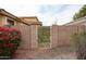 Backyard view of gate with plants, flowers, and gravel at 5415 E Mckellips Rd # 104, Mesa, AZ 85215