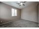 A carpeted bedroom features a ceiling fan and a window at 5415 E Mckellips Rd # 104, Mesa, AZ 85215