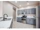 Well-lit kitchen featuring gray cabinets, stainless steel appliances, and a sleek countertop at 5415 E Mckellips Rd # 104, Mesa, AZ 85215