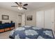 This bedroom features a blue quilt, blue dresser, ceiling fan, and sliding door closet at 6014 E Sayan Cir, Mesa, AZ 85215