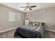 This bedroom features a ceiling fan, carpet, and a plaid comforter at 6014 E Sayan Cir, Mesa, AZ 85215